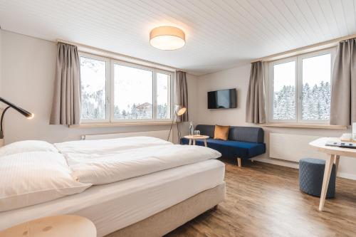 阿罗萨Hotel Alpensonne - Panoramazimmer & Restaurant的一间卧室配有一张大床和一张蓝色椅子