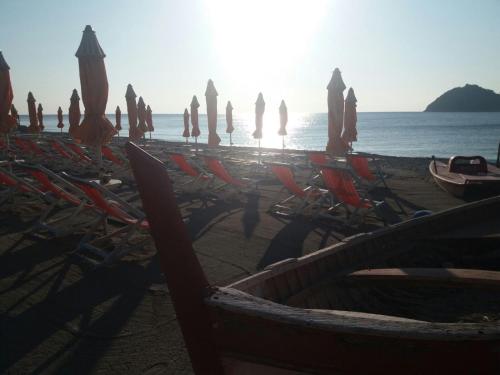 阿尔本加索尔酒店的海滩上的一把遮阳伞和椅子