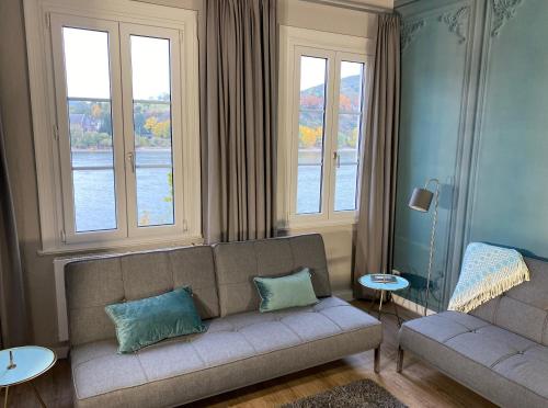 博帕德RHEIN-SUITES BOPPARD的带沙发和2扇窗户的客厅