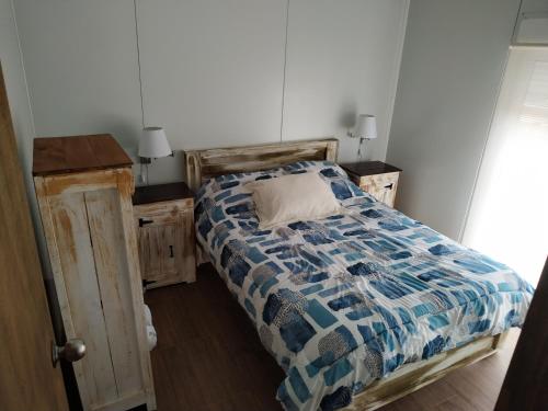 特立尼达岛Casita de Piedra 4的一间卧室配有一张带蓝色和白色棉被的床
