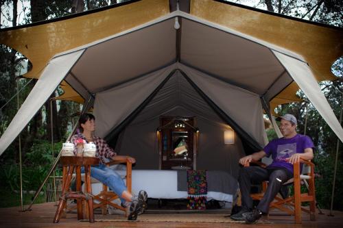 乌鲁班巴Glamping Chaska Ocupi的两人坐在帐篷前