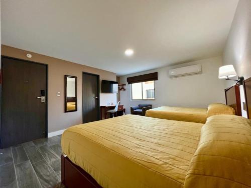 库利亚坎Neo Business Hotel的酒店客房配有两张床和一张书桌