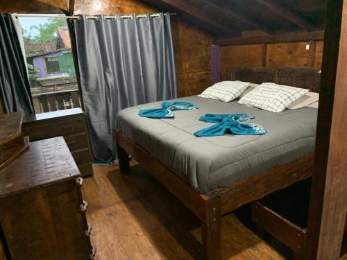 巴拉那瓜Chalé lawill ilha do mel的一间卧室配有一张带蓝色毛巾的床