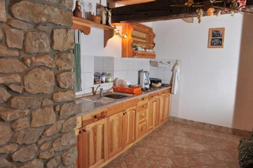 Šmarje pri JelšahVineyard Cottage Keglic的厨房配有木制橱柜和石墙