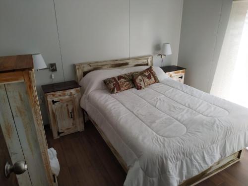 特立尼达岛Casita de Piedra 6的一间卧室配有一张带2个床头柜的大型白色床