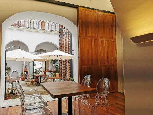 瓦哈卡市Casa de la Asunción的用餐室配有桌椅和遮阳伞