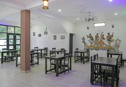克久拉霍Hotel Ramayana Khajuraho的用餐室配有桌椅
