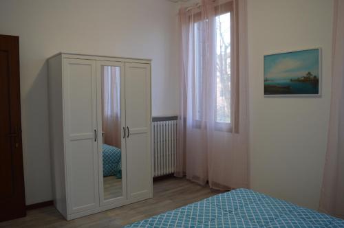 马格拉Noemi Venice Home的卧室配有白色橱柜和1张床