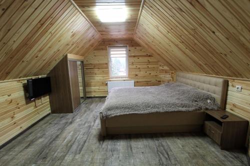 布克维Melody Hotel的小木屋内的卧室配有1张床和电视