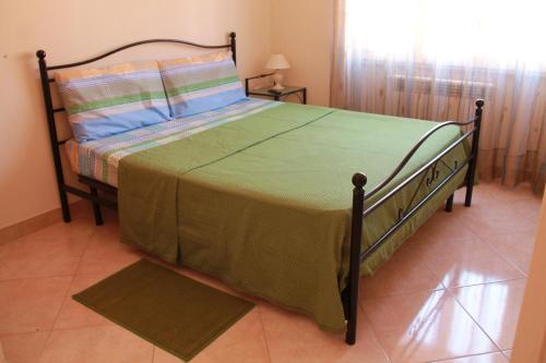 佩斯卡拉阿尔特亚酒店的一间卧室配有一张带绿色棉被的床