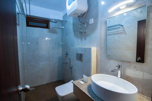 甘托克Hotel Shambhala的一间带水槽、卫生间和镜子的浴室