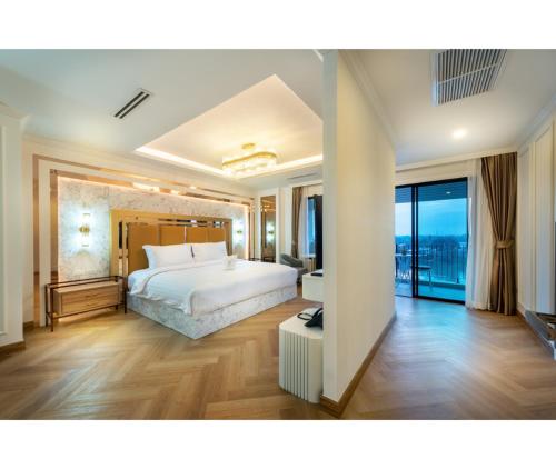 拉差汶里Nine River Hotel的卧室设有白色的床和大窗户