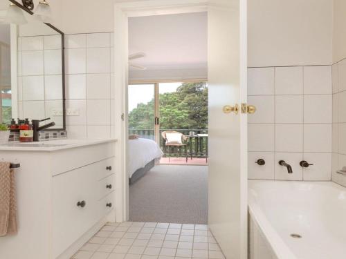 凯阿玛Tehidy Townhouse的带浴缸的白色浴室和卧室