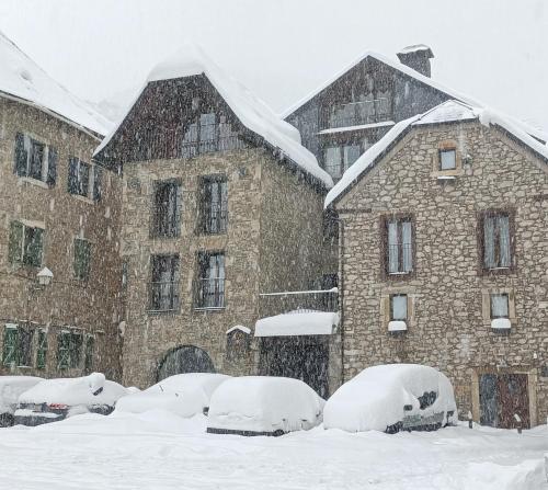 萨连特加列戈伊萨斯山谷酒店的一群雪覆盖在建筑物前的汽车