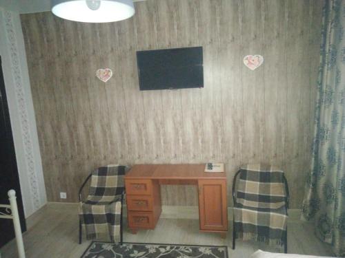 Vita-PochtovayaMotel Chalet的配有书桌和2把椅子的房间