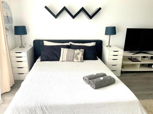 悉尼曼利中心公寓的卧室配有一张白色大床,上面装有袋子