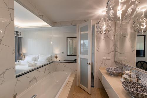 曼谷Siam Tharadol SHA Extra Plus的一间带浴缸和大镜子的浴室