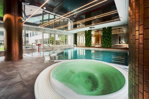 斯维诺乌伊希切ApartPark Baltic Home的大楼内带热水浴池的大型游泳池