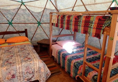 巴里查拉La Pacha Hostel的蒙古包内一间卧室,配有两张双层床