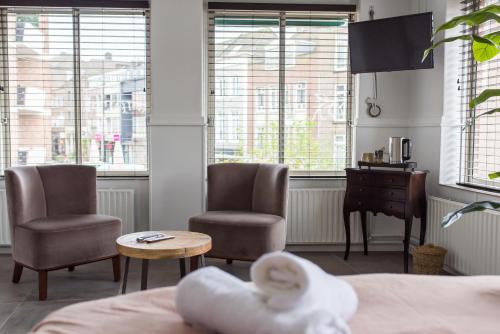 奈梅亨Koffie- en eethuis de Heerlijckheid的一间卧室配有两把椅子、一张桌子和一张书桌