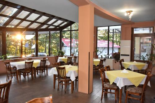 BeklemetoХотел Сима的餐厅设有桌椅和窗户。