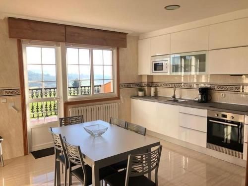 阿尔苏阿Casa Abeleira的带桌椅的厨房和带窗户的厨房