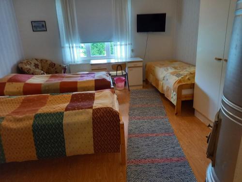 NorinkyläOpintola Bed & Breakfast的酒店客房设有两张床和电视。