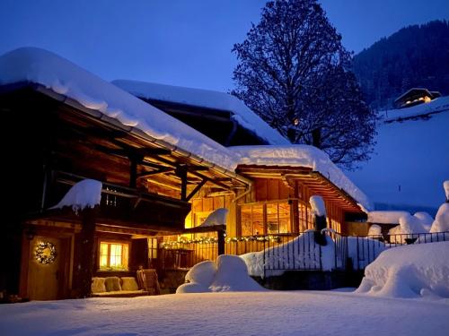 圣安特尼恩Berglodge Ascharina的雪覆盖的房屋,晚上有灯