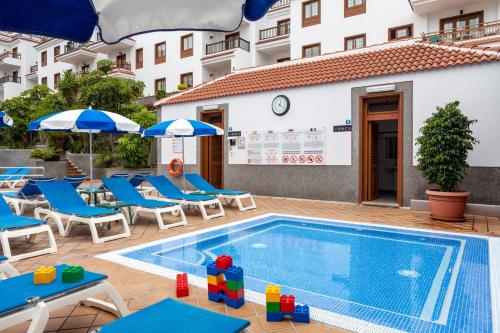 拉克鲁斯卡萨布兰卡公寓的酒店旁的游泳池配有椅子和遮阳伞
