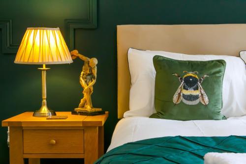 桑德兰The Mayfield Apartment Hotel的一间卧室配有一张床,枕头上装有蜜蜂