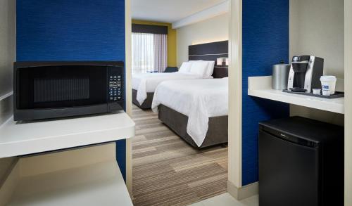 Saint Clair BeachHoliday Inn Express & Suites Windsor East - Lakeshore, an IHG Hotel的酒店客房带一张床和一台微波炉