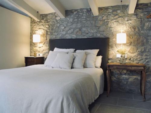 La PeraCAN SAFRA的一间卧室设有一张大床和石墙