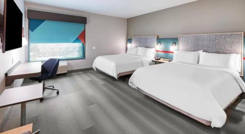 梅肯avid hotels - Macon North, an IHG Hotel的酒店客房配有两张床和一张书桌