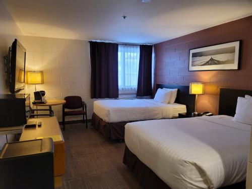 卡尔加里Roadking Inns Motel的酒店客房设有两张床和电视。