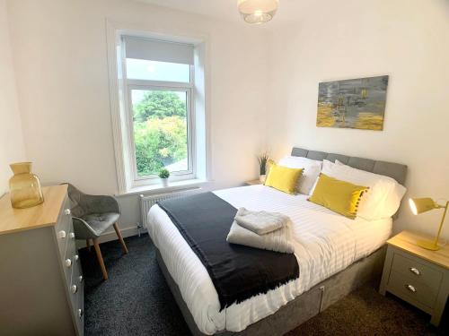 布里格豪斯CrowTrees的一间卧室配有一张带黄色枕头的床和一扇窗户