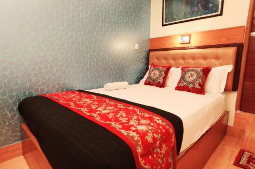 达卡Hotel Shalimar Motijheel - Centre of City的卧室配有一张大床,提供红色床单和枕头