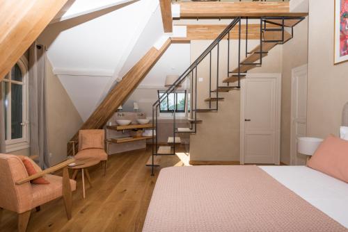 艾格-莫尔特La Maison du Môle的客房设有楼梯、床和椅子。