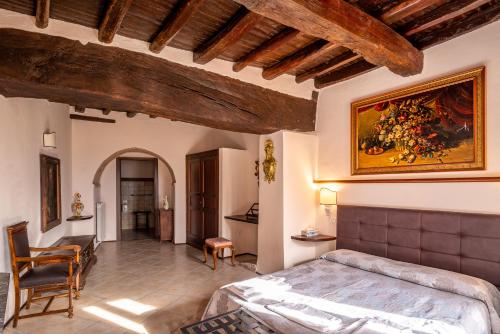 特雷维HOTEL TREVI Palazzo Natalini的卧室配有一张床,墙上挂有绘画作品