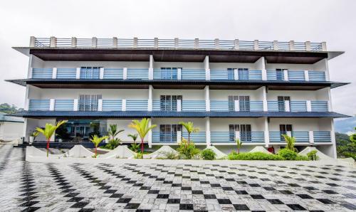 蒙纳Treebo Trend Misty Garden Resorts With Mountain View的一栋设有蓝色阳台和 ⁇ 板的建筑