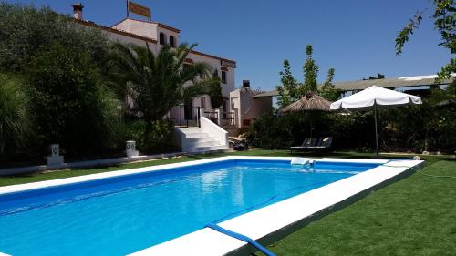 AlisedaApartamentos Turísticos - Hostal Los Alisos的一座房子的院子内的游泳池