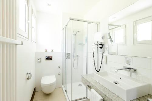 韦默尔斯基兴Seminar- & Tagungshotel Große Ledder的白色的浴室设有水槽和淋浴。