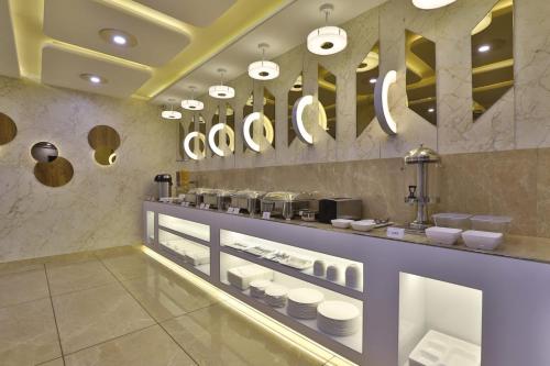 巴罗达Hotel Pearl的餐厅设有餐具和镜子的柜台