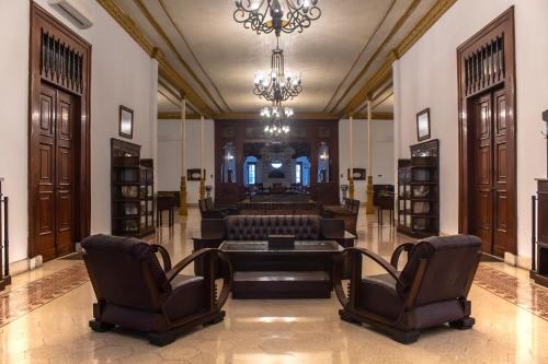 岩望Daroessalam Syariah Heritage Hotel的客厅配有沙发、椅子和吊灯
