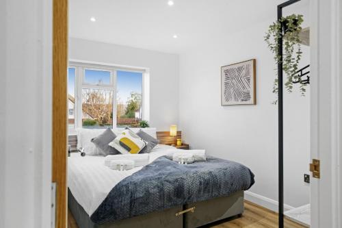 梅德斯通Modern Bungalow in Maidstone sleeps 5 with free parking的白色的卧室设有床和窗户