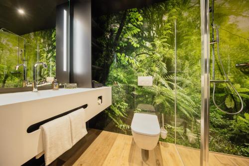 斯图加特Rioca Stuttgart Posto 4的浴室配有淋浴,墙上挂有森林壁画