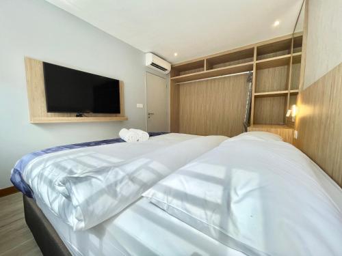 瓜埠LV Modern Suite Langkawi by Zervin的一间卧室配有2张白色的床和平面电视