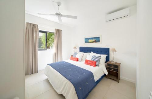 康隆尼角Nautilya Apartment by LOV的一间卧室设有蓝色的床和窗户。