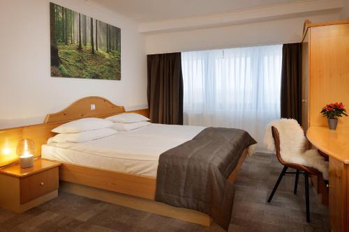 兹雷切普兰佳酒店的配有一张床和一张书桌的酒店客房