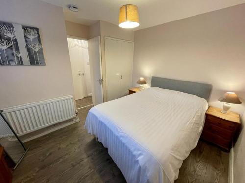 伦敦德里Bishop's Gate Apartment的卧室配有一张白色大床和镜子