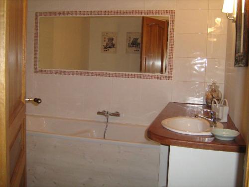 锡河边的圣奥班格内提磨坊度假屋的带浴缸、水槽和镜子的浴室